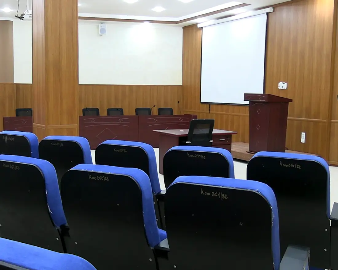 Conference room with a panel table, lectern and projection screen