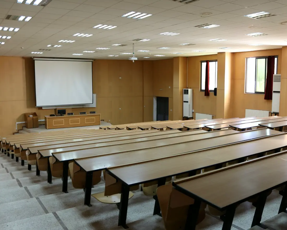 A lecture theatre seen from the back rows, facing the screen
